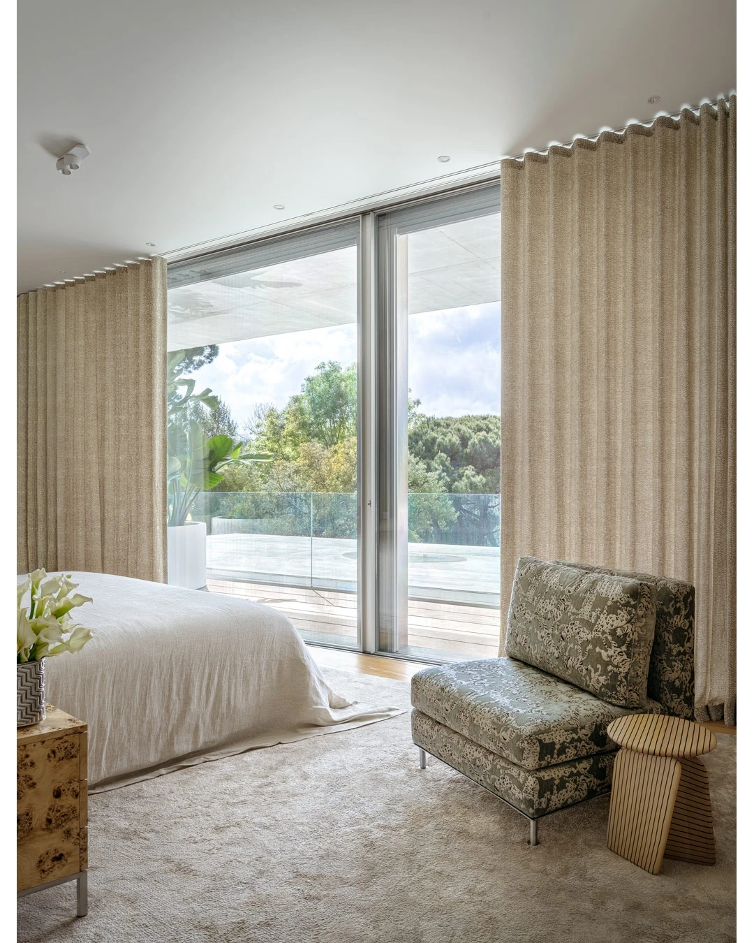 Master bedroom with sculptural chairs and curated artwork.
