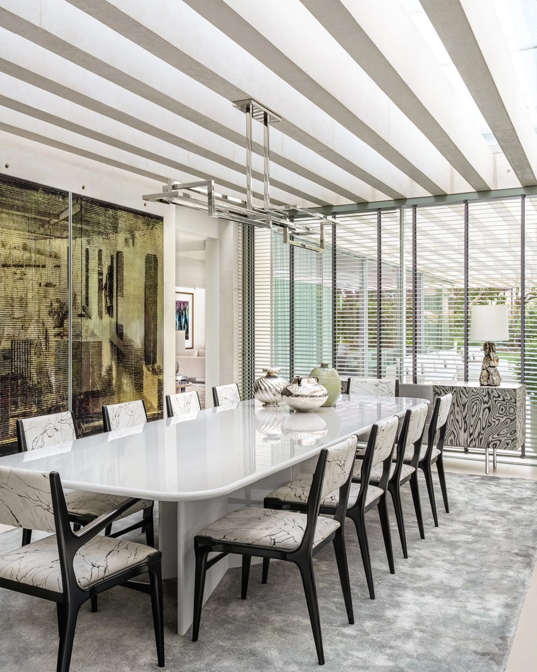 Contemporary dining room with sculptural chairs, oval table and unique lighting.