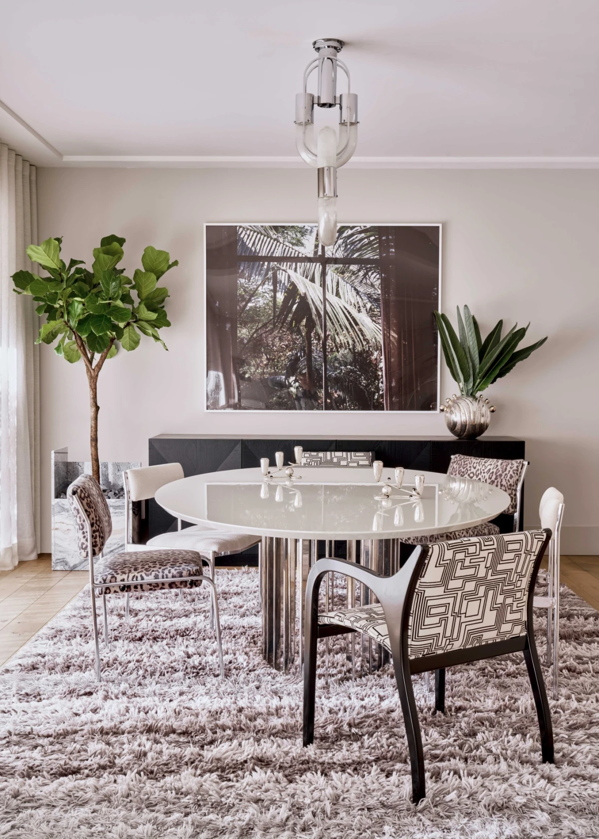Dining room design with timeless furniture and contemporary art in a modern setting.