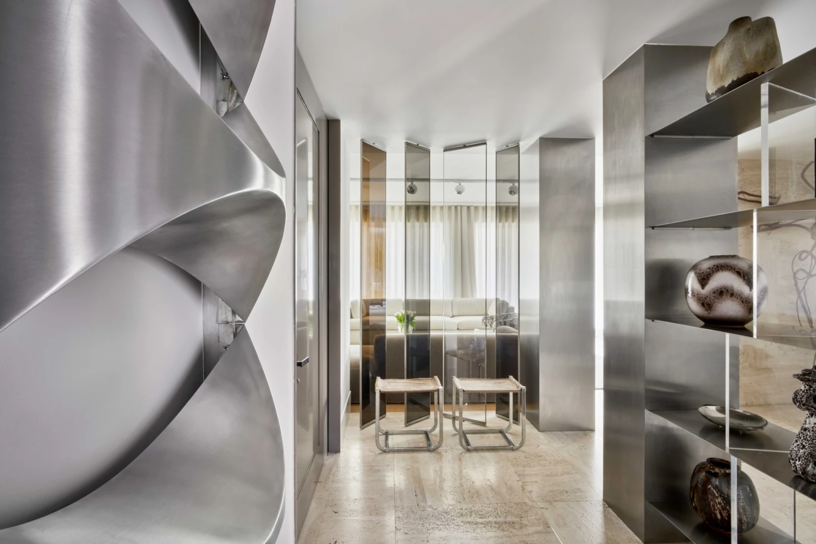 Brutalist hallway design with steel finishes and abstract wall sculpture.