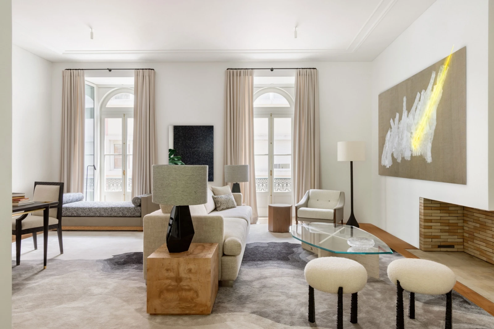 Serene living room with a contemporary interior design, neutral tones, bespoke rug in grey tones, beige sofa, wood sidetables and stools by designer Hamrei